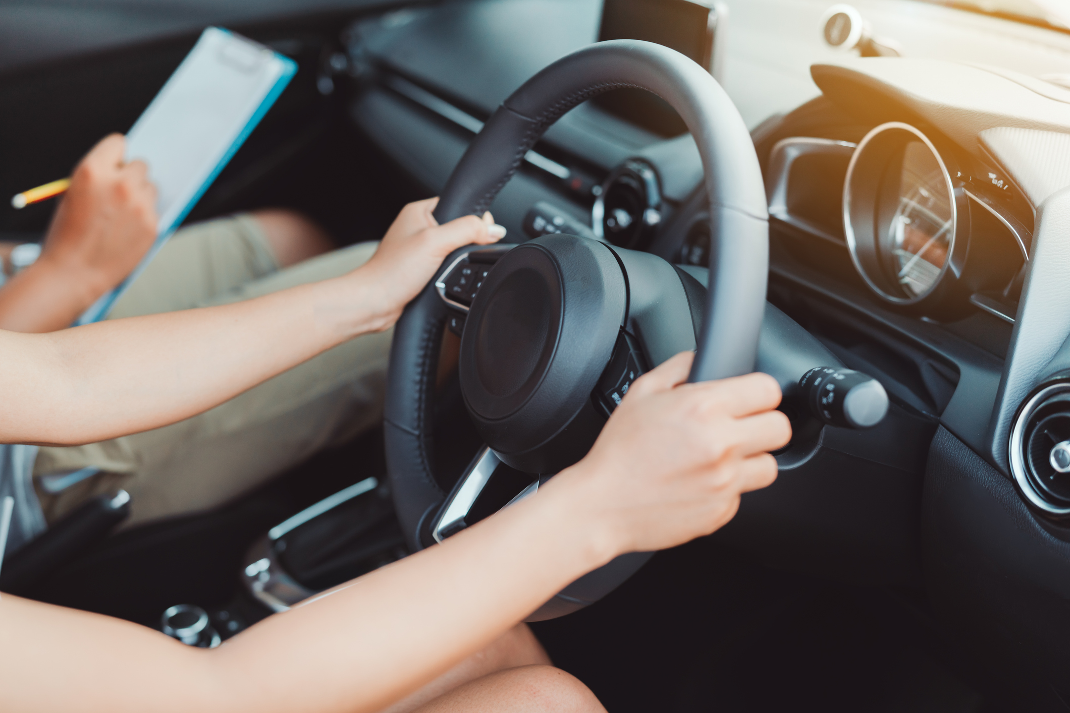 image of student holding a steering wheel during a driver lesson
